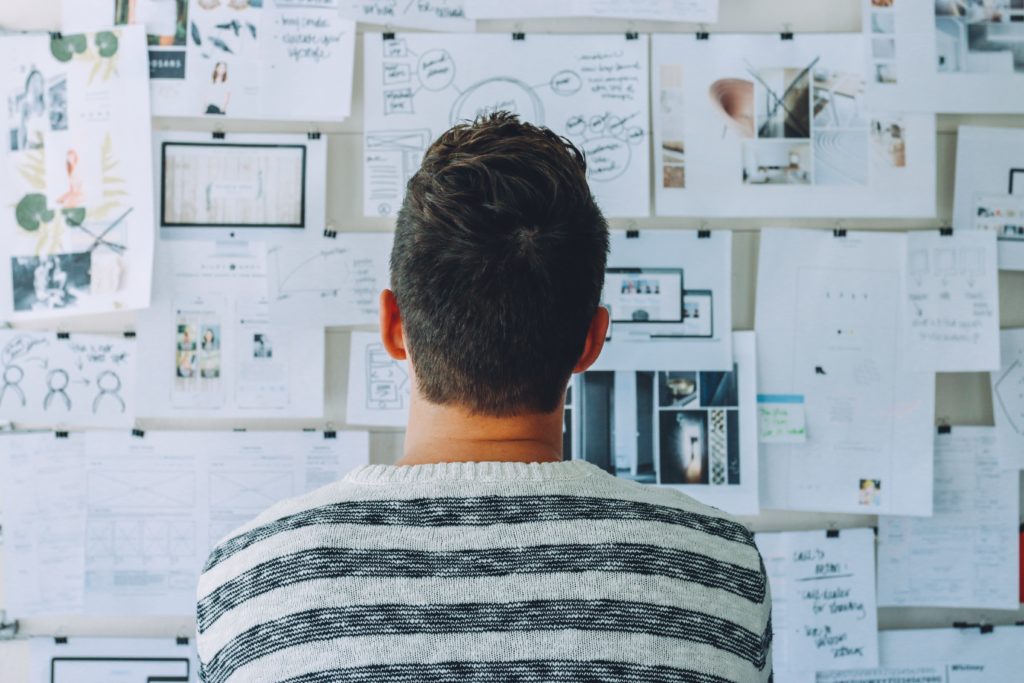 Money-Saving-Tipp Nr. 1 "Haushaltsplan" 10 Mann der Nachdenkt udn auf große Wand schaut