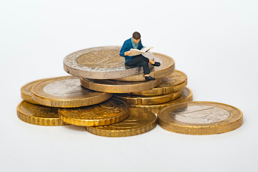 Money-Saving-Tipp Nr. 1 "Haushaltsplan" 13 Mann sitzt auf Geldberg